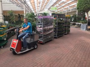 Xerowaste.ca | V-Move 650 tow tractor tug used at a nursery to pull racks of plants | Stock chaser | Sit down riding tug