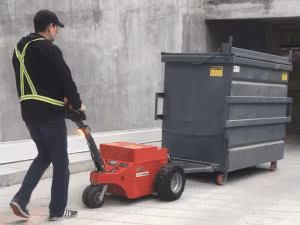 Xerowaste Xerowaste Solutions Zero-Emission Material Handling Equipment | V-move load movers and Bin Butler trailers | V-move XL+ moving 4-yard compactor receiving bin on a sloped driveway