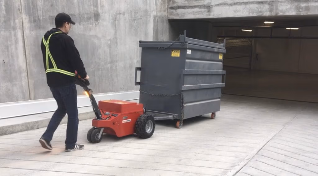 v-move xlplus and 4-yard compacted bin Xerowaste Solutions Zero-Emission Material Handling Equipment | V-move XL+ moving 4-yard compactor on driveway slope