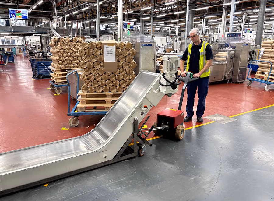V-move M electric tug | Moves up to 3,307 lb 6 Xerowaste | V-move M moving a heavy motorized conveyor.
